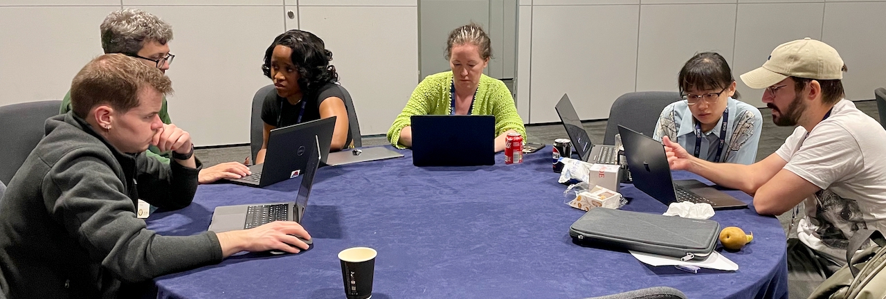 People working at a table at CoFest 2025